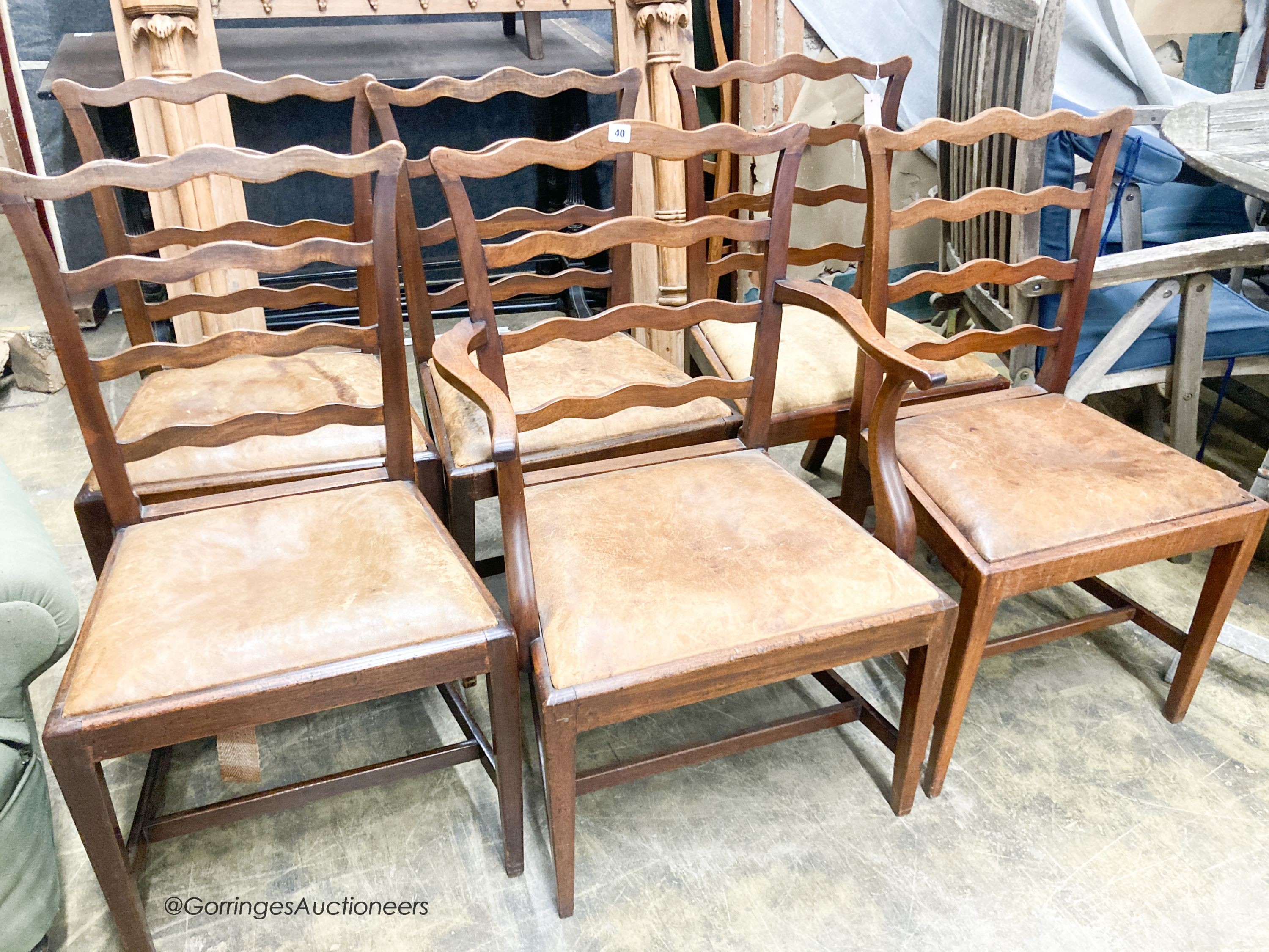A set of six George III mahogany ladderback dining chairs with leather drop in seats (one with arms)